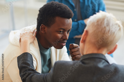 High angle view at young African-American man smiling gratefully to psychologist while while in support group circle, copy space photo