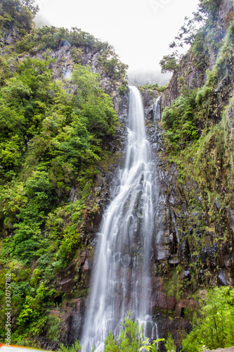 Long exposure Risco waterfall on madeira island, portugal, in the middle of the tropical forest