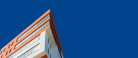 modern architecture building triangle shape panoramic urban photography concept foreshortening from below on vivid blue sky wallpaper pattern background space for copy or your text