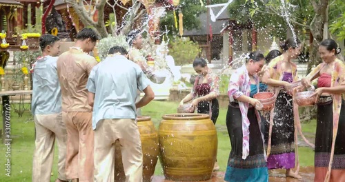 The summer holiday water festival in april the people celebrate traditional asian thai songkran the beautiful women and men smiling splash water with hapiness.