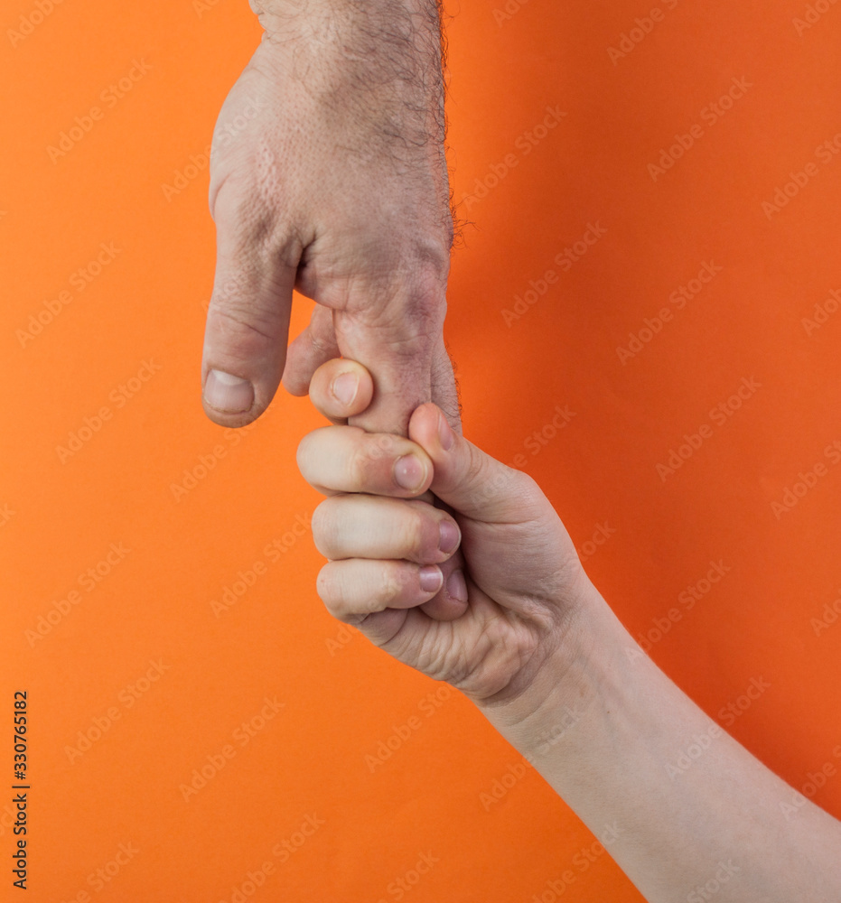 Obraz premium father's hand and child son over color background, trust family concept
