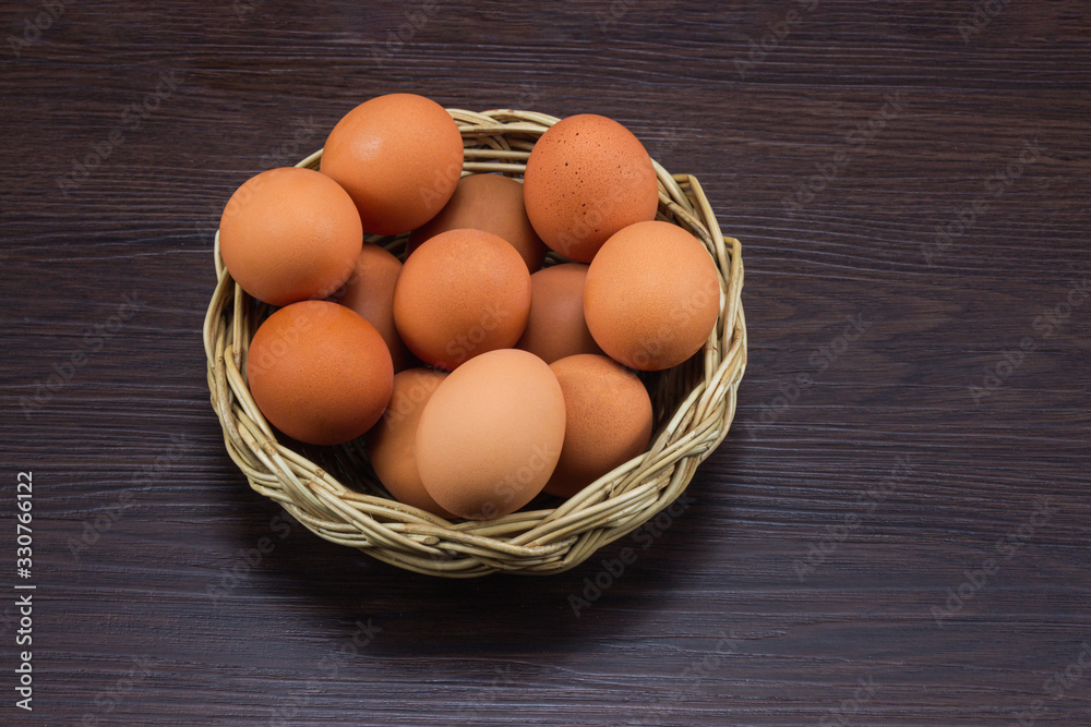 Eggs chicken in the basket on brown dark wooden floor. Eggs chicken in the basket on brown dark wooden floor.