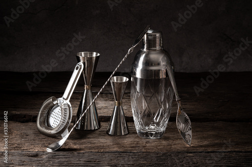 bartender equipment shaker strainer jigger on wood background with copy space photo