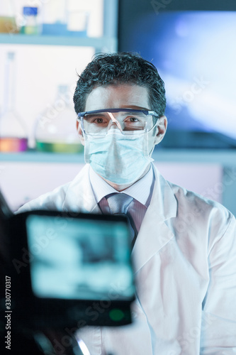 Laboratory hospital clinic doctor, scientist or exper, wearing protacive mask while addressing public in media interview explaining preventive measures against corona virus pandemic outbreak. photo