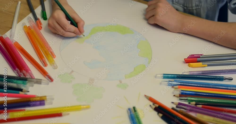 Child boy draws planet for earth day. Protection of enviroment, Mother Earth Day greeting and celebration. Save our planet! Concept of art learning and education, love earth , save world and unity Child boy draws planet for earth day. Protection of enviroment, Mother Earth Day greeting and celebration. Save our planet! Concept of art learning and education, love earth , save world and unity