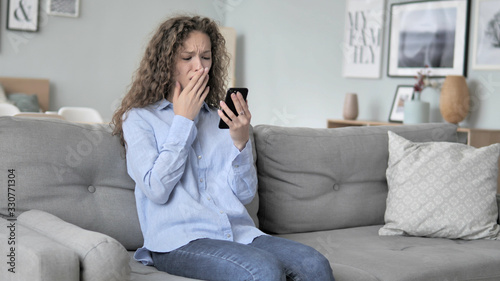 Curly Hair Woman in Shock by Loss while Using Phone