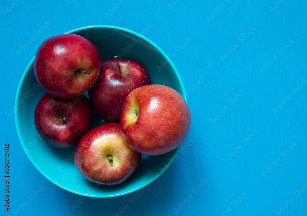 Fresh red apples on blue background, top view copy space Fresh red apples on blue background, top view copy space
