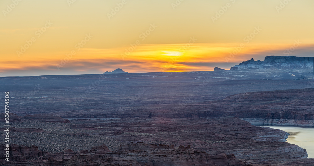 Panoramic image of the morning sky with Lake Powell in the foreground in the barren desert surrounding Page, Arizona.