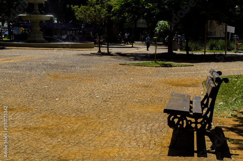 Banco de madeira em espaço público. Fonte de água.	 photo