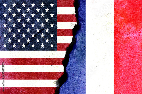 american and french flag on a stone wall with a crack. Confrontation concept photo