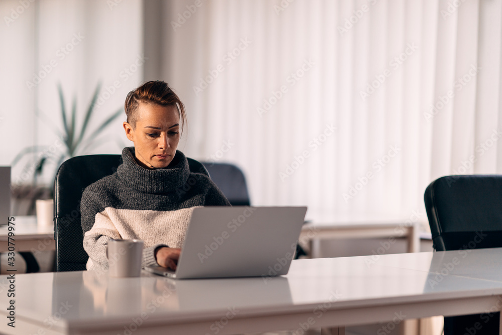 Woman sitting at the desk and using laptop Woman sitting at the desk and using laptop