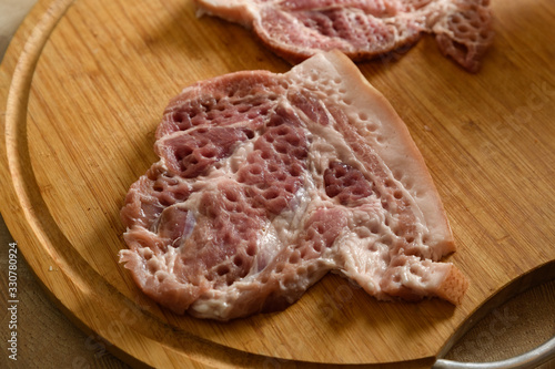sliced raw pork meat for chops on a wooden cutting Board