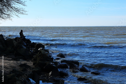 the boy looks thoughtfully at the waves in the bay
