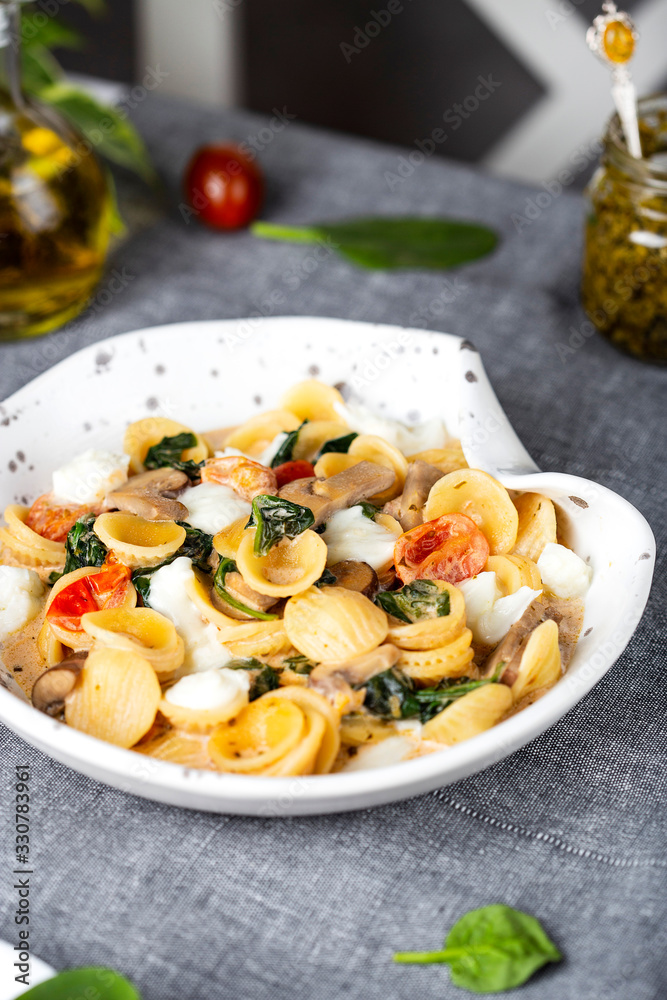 Italian orecchiette pasta with spinach and tomatos
