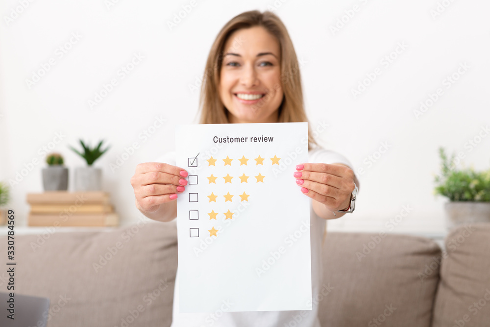 Happy woman holding five star to increase rating of company Happy woman holding five star to increase rating of company