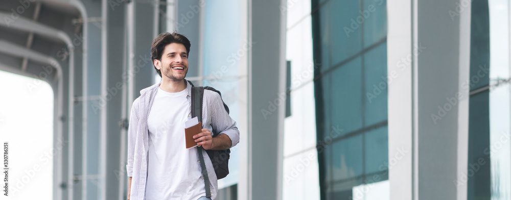 Fototapeta premium Ready For Journey. Handsome Young Man Walking Near Airport Terminal