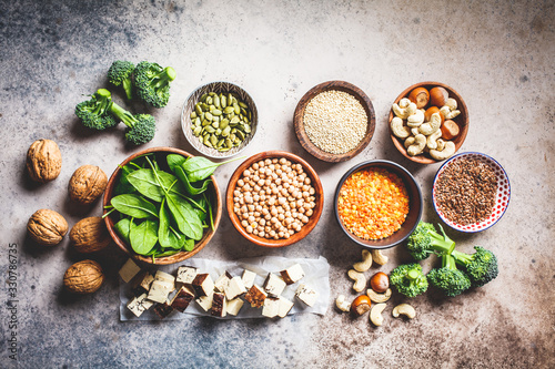 Vegan sources of protein background, top view. Tofu, chickpeas, lentils, nuts, spinach and broccoli - vegetable proteins.