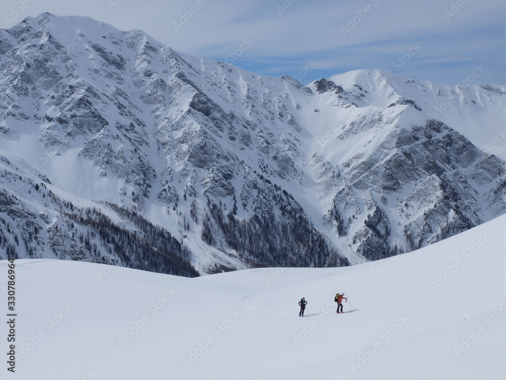 Skieurs de ski de randonnée et alpiniste en montagne qui skient sur la neige et la glace en plein soleil des alpes dans le Queyras de saint Véran Skieurs de ski de randonnée et alpiniste en montagne qui skient sur la neige et la glace en plein soleil des alpes dans le Queyras de saint Véran