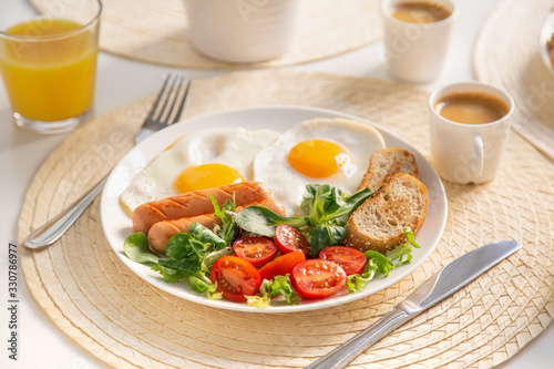 fried eggs, sausages and fresh vegetables for breakfast