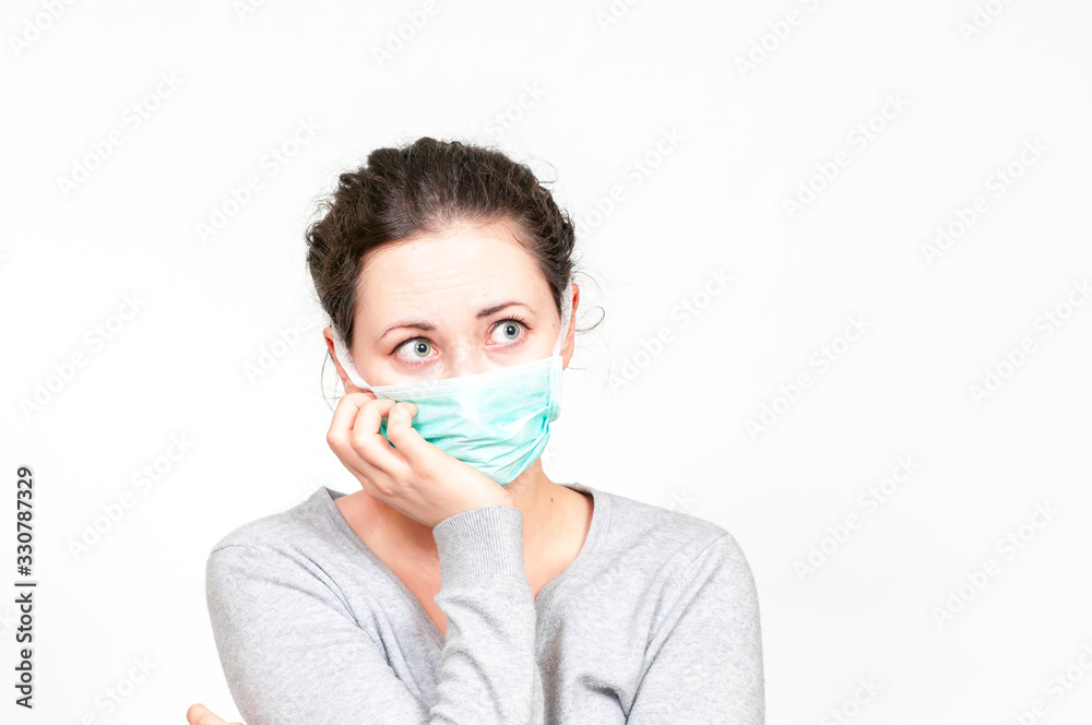 caucasian brunette woman in protective medical mask on face protection for spreading of disease virus SARS-CoV-2, Coronavirus, COVID-19. white background caucasian brunette woman in protective medical mask on face protection for spreading of disease virus SARS-CoV-2, Coronavirus, COVID-19. white background