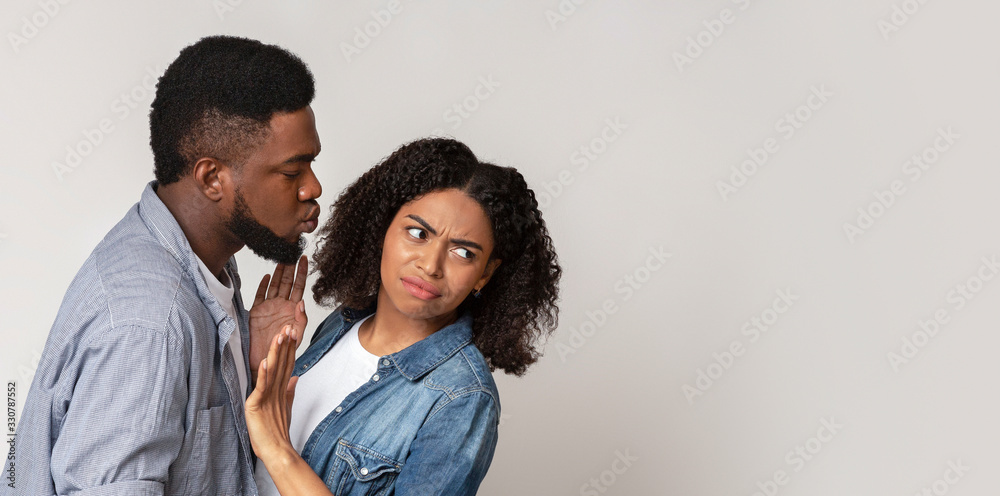Coronavirus Precautions. Disgusted Black Woman Pushing Away Boyfriend, Refusing His Kisses Coronavirus Precautions. Disgusted Black Woman Pushing Away Boyfriend, Refusing His Kisses