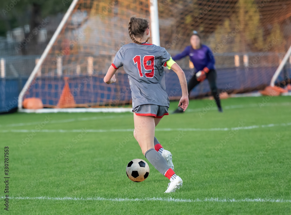 High school girl competing in a soccer match in south Texas