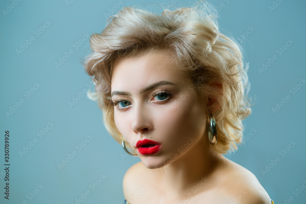 Close up portrait of young beautiful woman with pinup style posing on gray Isolated background. Copy, empty space for text.