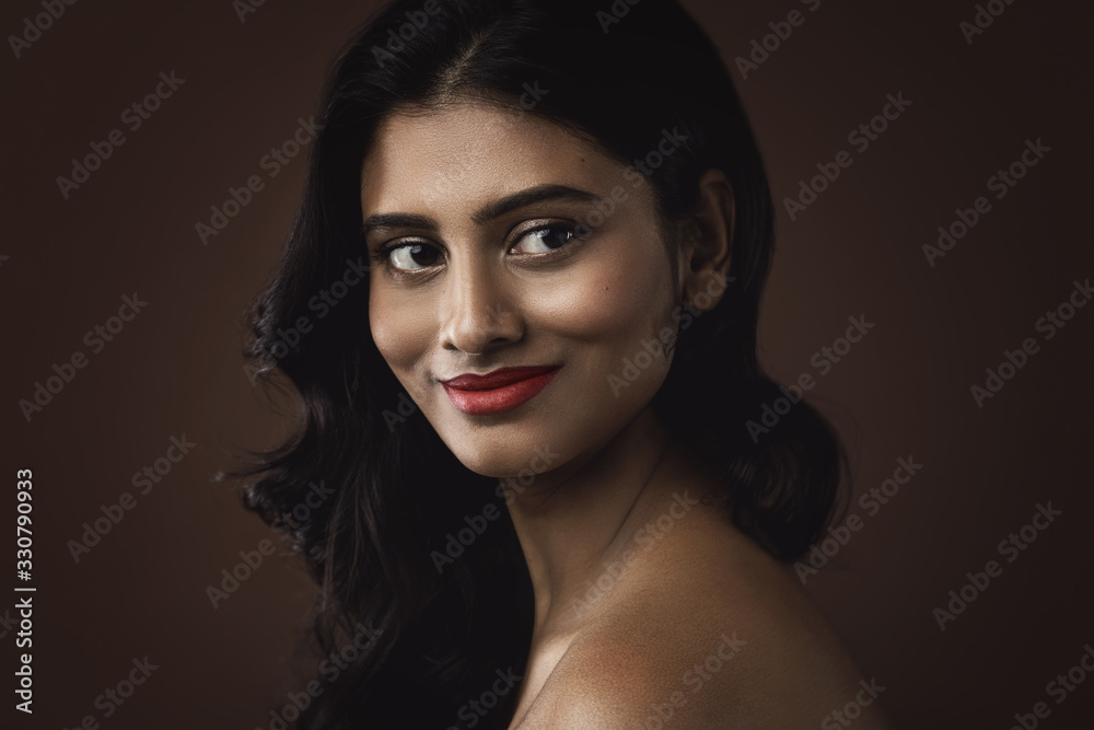 Fototapeta premium Indianka z pięknym makijażem i fryzurą na brązowym tle