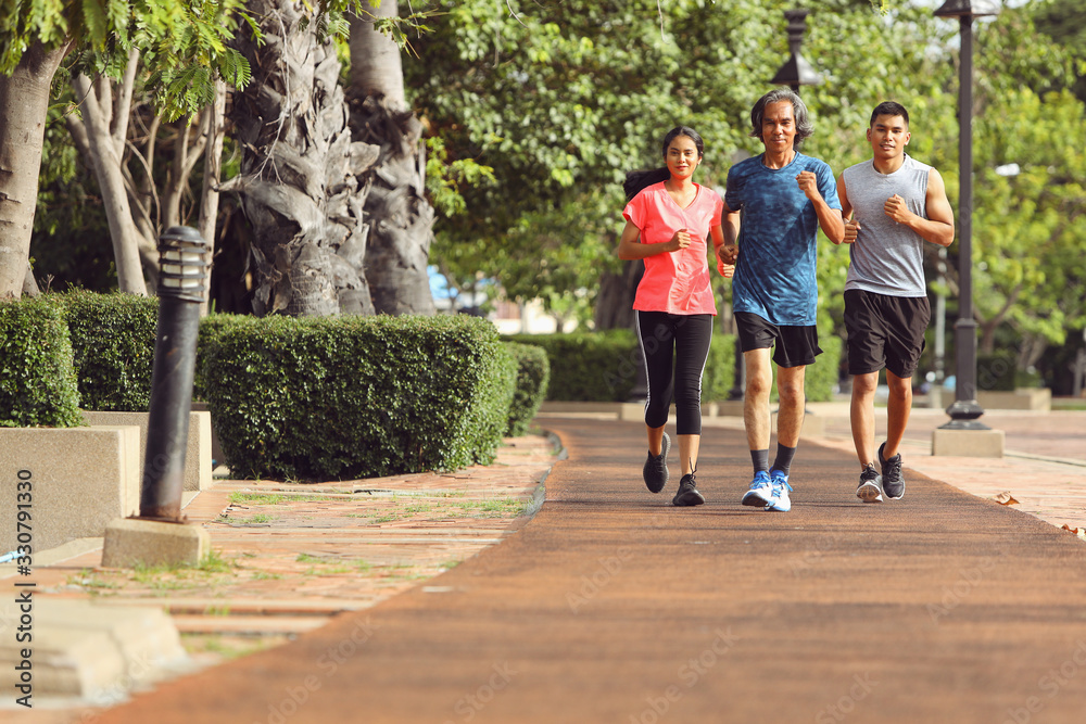 Fototapeta premium An old man in Asia is jogging with his son and daughter in the morning.