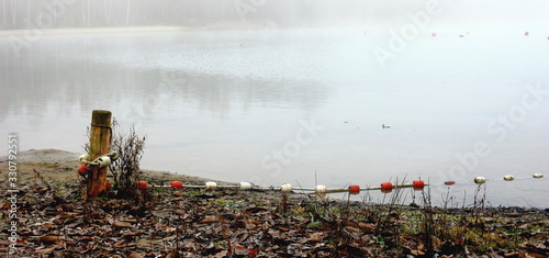 Foggy, wintery images of a lake: the Plas in Rotselaar in Flanders, Belgium. De Plas is an artificial lake created by sand extraction.  Swimming and windsurfing in the summer. photo