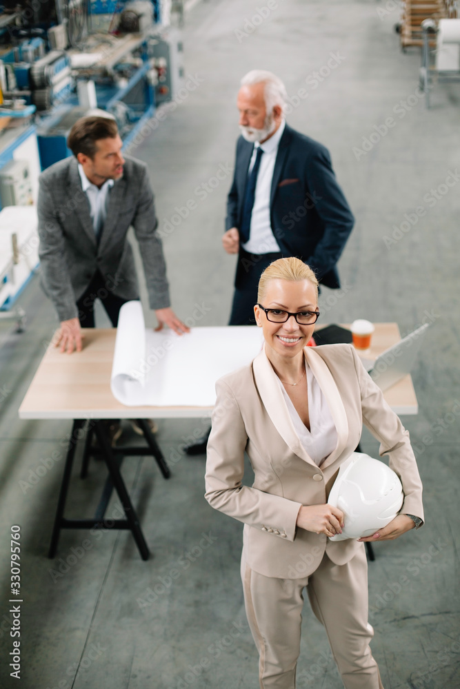 Colleagues working on project. Team of architects discussing business in factory. Colleagues working on project. Team of architects discussing business in factory.