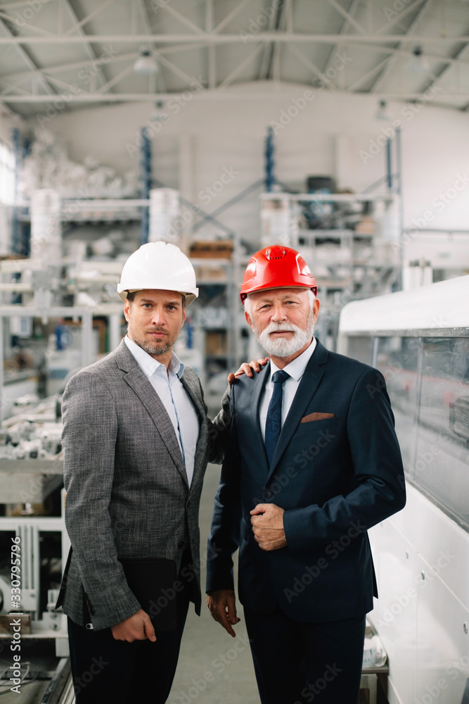 Colleagues working on project. Team of architects discussing business in factory. Colleagues working on project. Team of architects discussing business in factory.