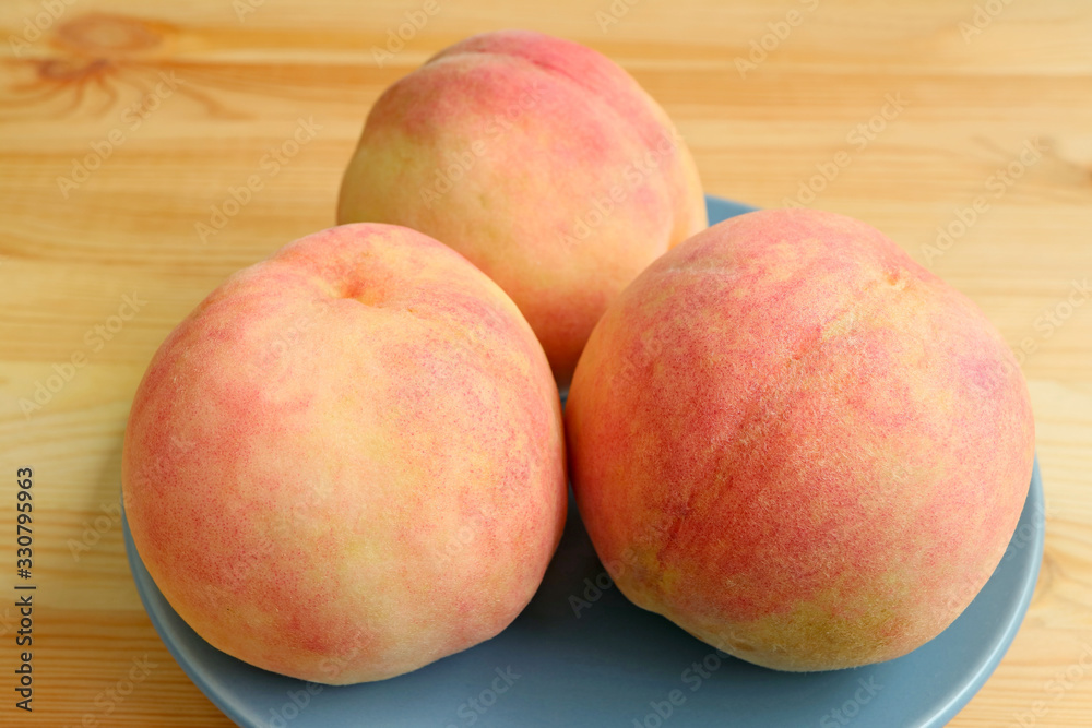 Plate of Three Fresh Ripe Peaches on Wooden Table Plate of Three Fresh Ripe Peaches on Wooden Table