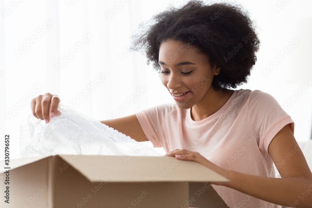 African american customer remove packaging from purchase