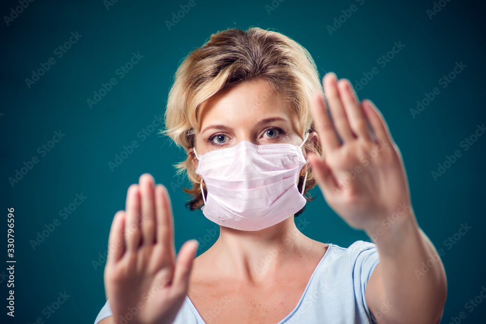 A portrait of woman with face medical mask showing stop gesture. People, healthcare and medicine concept A portrait of woman with face medical mask showing stop gesture. People, healthcare and medicine concept