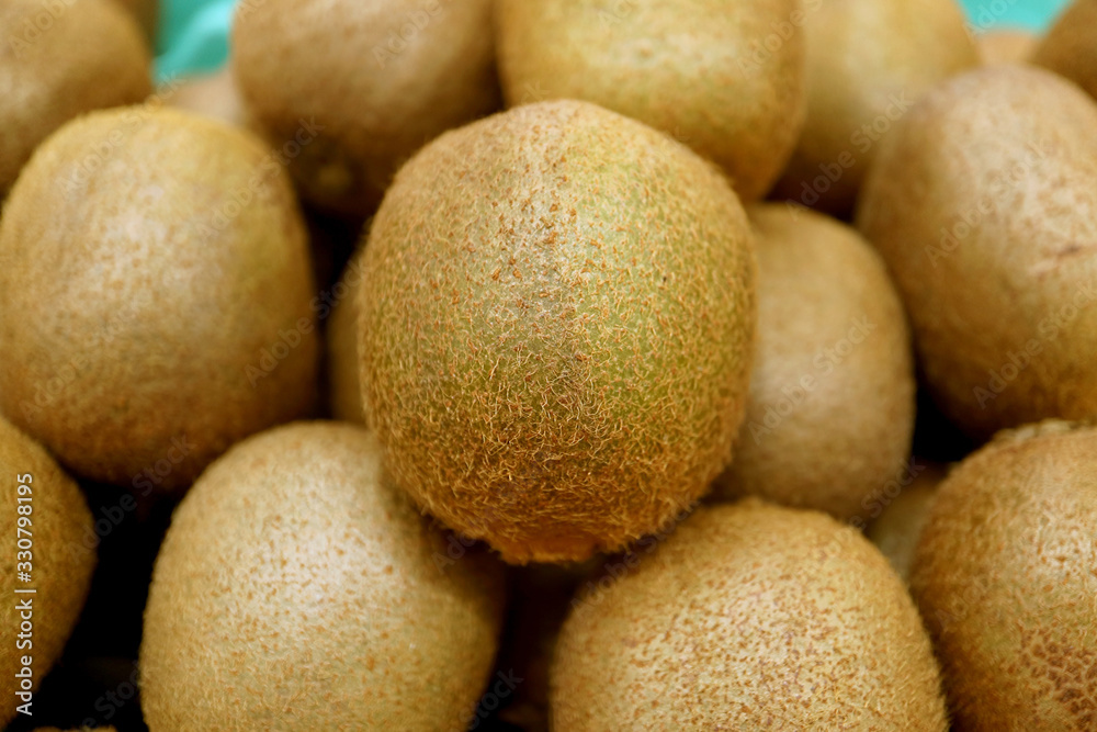 Closeup Fresh Kiwi Fruit on blurry Kiwi Fruits Pile Closeup Fresh Kiwi Fruit on blurry Kiwi Fruits Pile