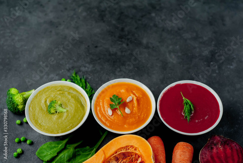 Set of vegetable soups. Broccoli, spinach, green peas soup. Pumpkin and carrot soup. Beetroot and carrot soup on a stone background with copy space for your text