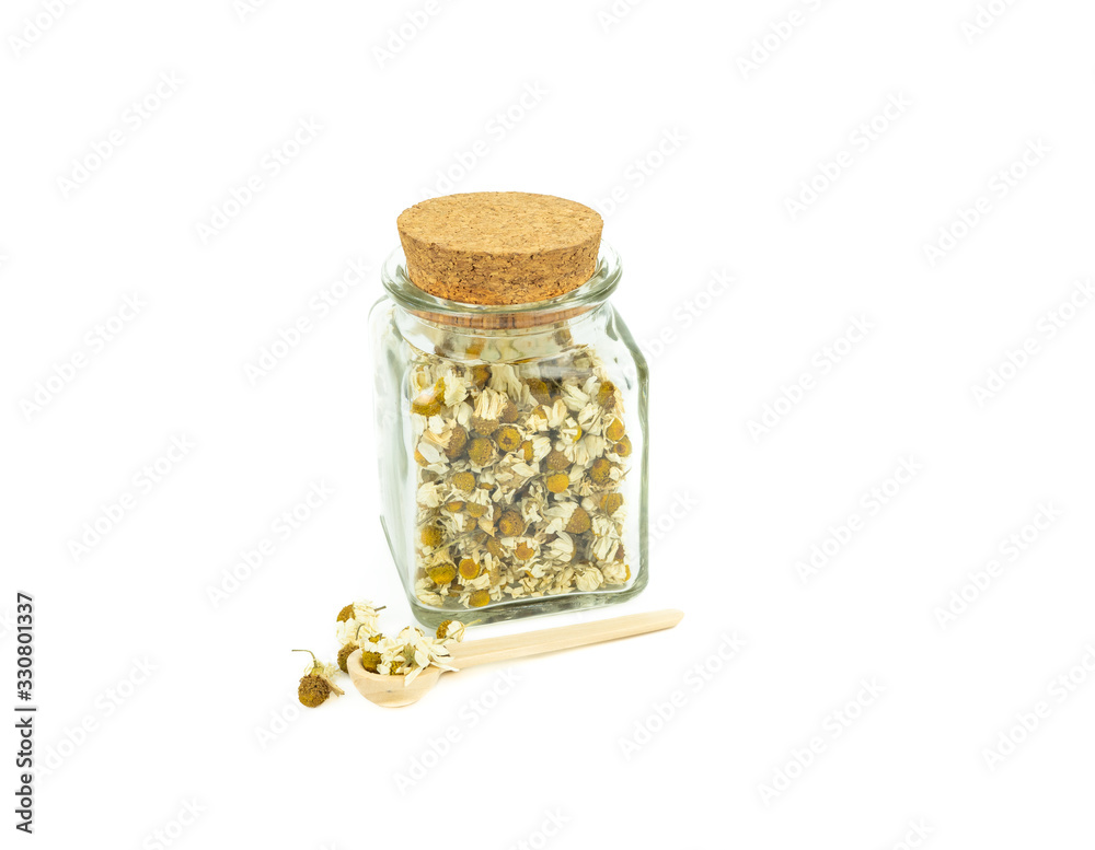 Glass jar full of camomile on a white background. Natural medicine concept.