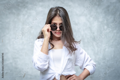 Asian beautiful woman with yellow skin, long black hair, wearing a white shirt, jeans showing her emotions.  Cement wall background-01