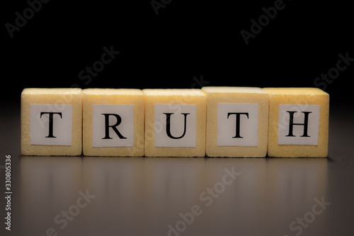 The word TRUTH written on wooden cubes, isolated on a black background...