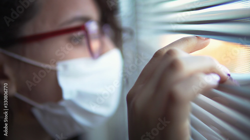 Corona Virus Quarantine Isolation. Sick woman of corona virus looking through the window and wearing mask protection and recovery from the illness in hom