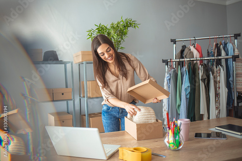 Woman working at home, selling items online. Online shopping makes happy a lot of people. Woman packing item that she sells online. Items that I send has to be perfect photo