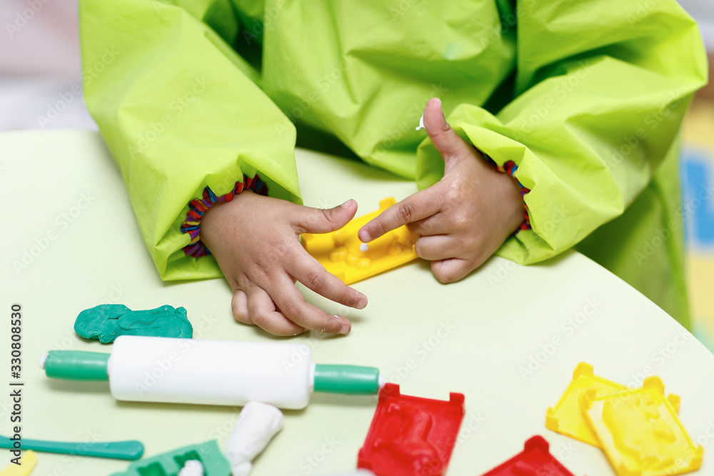 Fototapeta premium Little boy playing with plasticine.