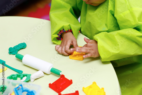 Little boy playing with plasticine.