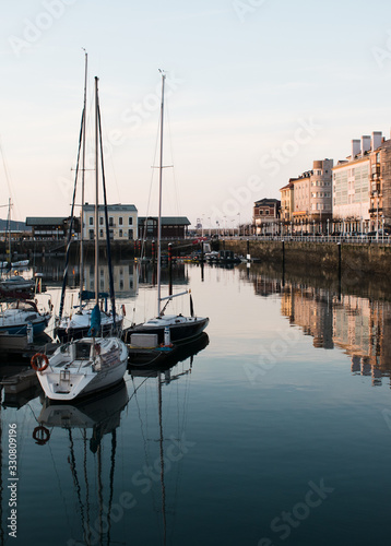 Barcos veleros amarrados en el puerto de Gijón en una tarde tranquila photo