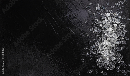 Quadro su tela Pile of crushed ice on black stone background