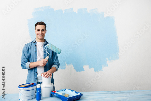 Smiling young man with tools and paint