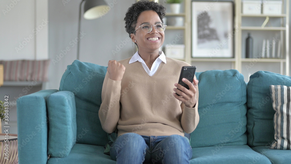Obraz premium The Cheerful Girl Using phone while Sitting on Couch