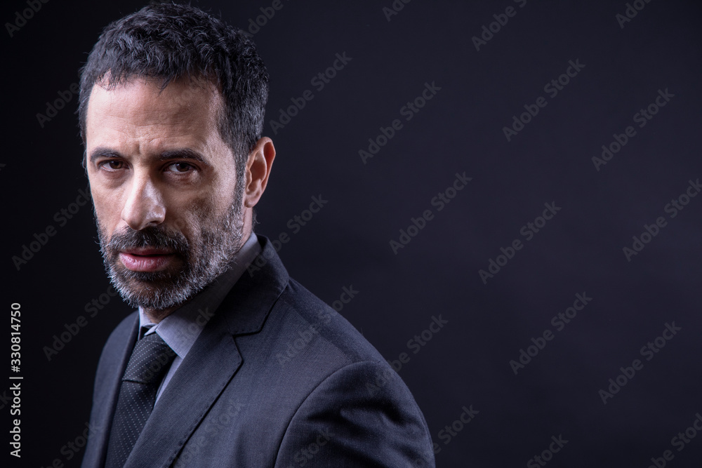 Ritratto di manager con barba vestito in abito e Isolato su sfondo nero