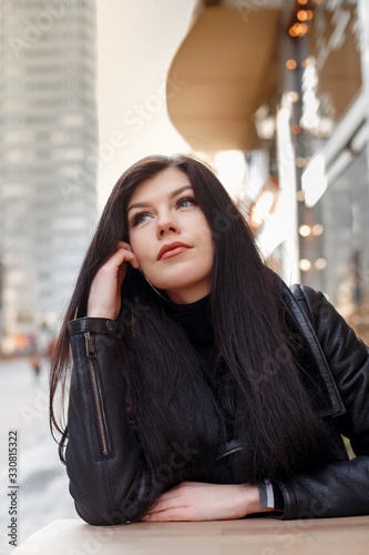Portrait of a girl in the city. Beautiful brunette in the city streets. Stylish woman travels the cities of Europe. © ibilyk13